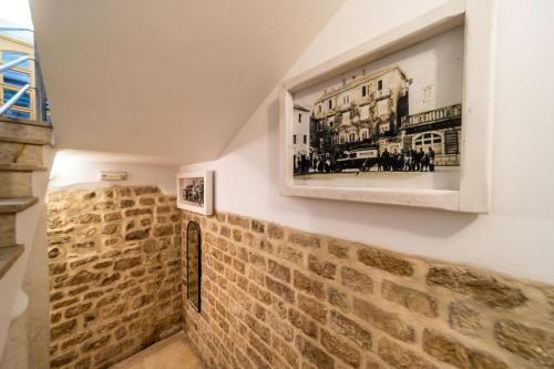 a room with a wall with a picture on the wall at Apartments Residence Astoria in Rab