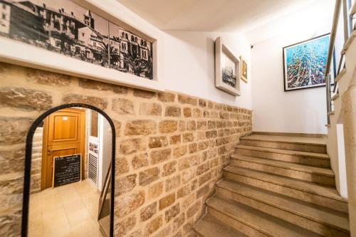 a staircase in a building with a stone wall at Apartments Residence Astoria in Rab