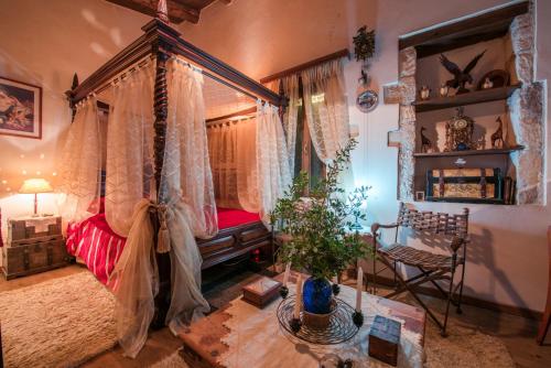 a bedroom with a canopy bed and a table at Myli Unique-Exotic Villa in Kapedhianá