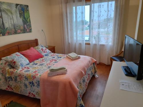 a bedroom with a bed and a desk and a television at Aguda Mar - V N Gaia in Aguda