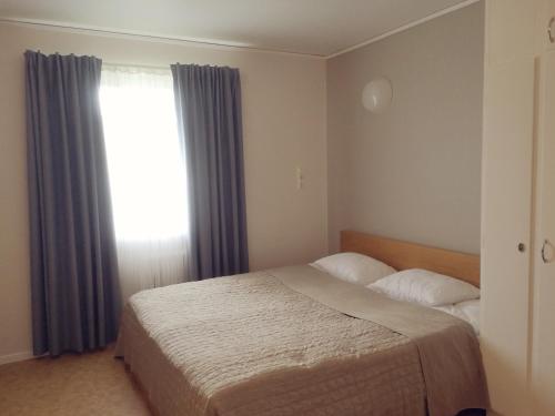 a bedroom with a bed and a window with curtains at Norra NY Hostel in Stöllet