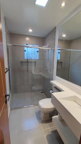 a bathroom with a glass shower and a toilet at Casa do Sérgio lindo loft ideal para casa e pequena família,moderno e confortável in Paraty