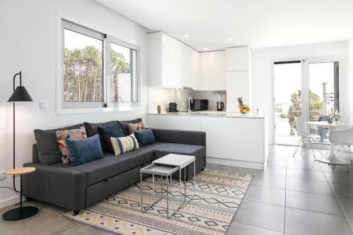 a living room with a couch and a kitchen at Nazaré Sea View Apartment in Nazaré