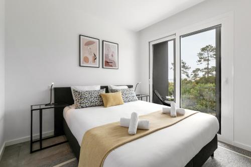 a bedroom with a large bed with a large window at Nazaré Sea View Apartment in Nazaré
