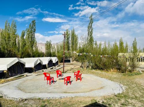 a group of red chairs sitting in a circle at Hotel Nubra Delight and Camps in Hundar