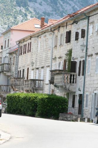 an old stone building with balconies on a street at Apartments Saxo in Kotor