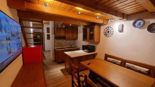 a room with a kitchen and a dining room at La Casa Degli Orsi - presso Sussy Residence in Falcade