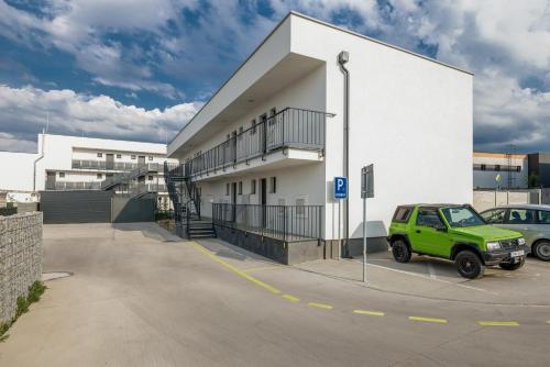 a green jeep parked in a parking lot in front of a building at Apartmán LUXURY in Liptovský Mikuláš