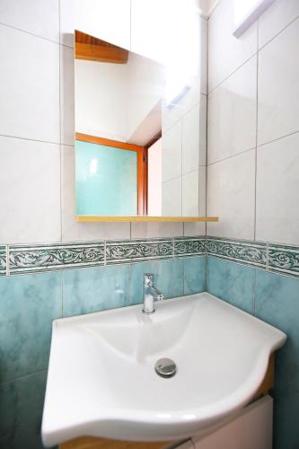 a bathroom with a white sink and a mirror at Seascape Villas in Vlorë