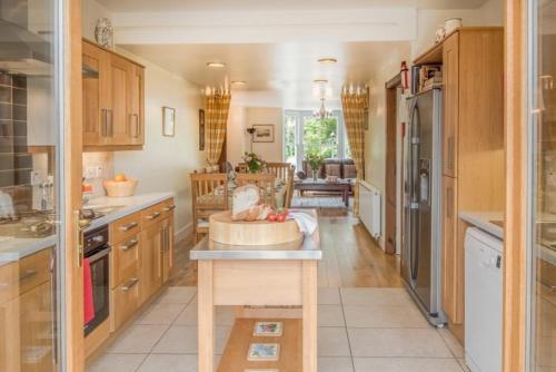 a large kitchen with wooden cabinets and a counter at Drumrunie in Braemar