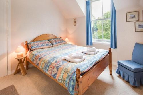 a bedroom with a bed and a blue chair at Drumrunie in Braemar
