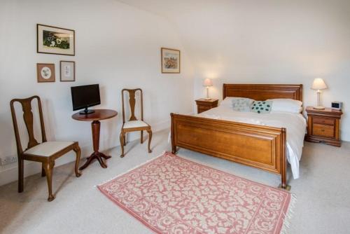 a bedroom with a bed and a desk with a computer at Drumrunie in Braemar