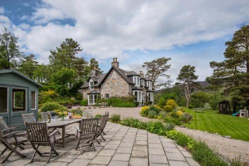 a patio with a table and chairs in front of a house at Drumrunie in Braemar