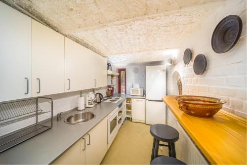 a kitchen with white cabinets and a counter top at Ádám Apartman in Balatonföldvár