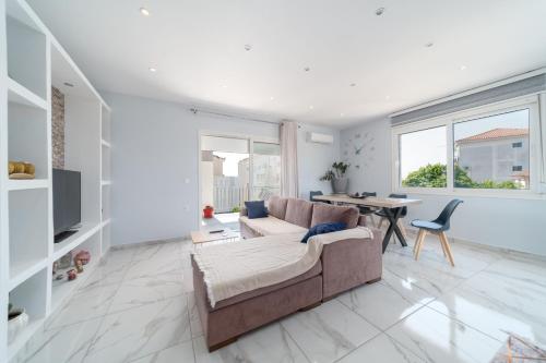 Amazing New Apartment in Skala في سكالا كيفالونياس: غرفة معيشة مع أريكة وطاولة