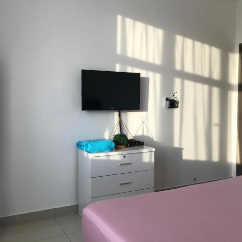 a bedroom with a bed and a tv on a dresser at Homestay SKS Apartment Larkin Johor Bahru in Johor Bahru