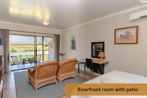 a bedroom with a bed and a room with a balcony at Crocodile Bridge Safari Lodge in Komatipoort
