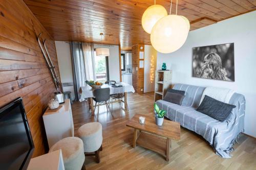 a living room with a couch and a table at Joli T2 - Vue sur Lac - 5 min du plan d'eau d'Embrun in Baratier