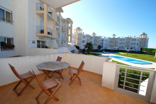 a balcony with a table and chairs and a pool at Turtle - 3 bedroom apartment in Nazaré with 2 shared pools and private terrace in Nazaré