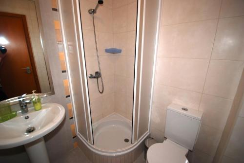 een badkamer met een douche, een toilet en een wastafel bij Turtle - 3 bedroom apartment in Nazaré with 2 shared pools and private terrace in Nazaré