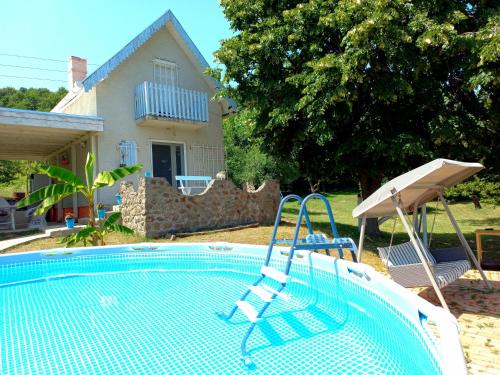 a swimming pool in a yard with a house at Honey hill apartment Fruska Gora in Čerević
