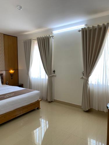 a bedroom with a bed and a large window at Hoa Phuong Hotel in Hai Phong