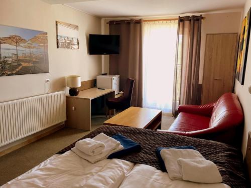 a hotel room with a bed and a desk at Arenia Łeba -Filia Kompleksu ARENA SŁOŃCA in Łeba