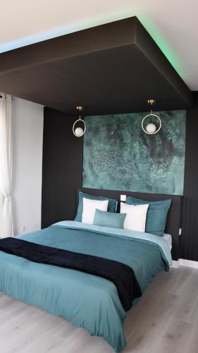 um quarto com uma cama grande e almofadas azuis e brancas em Appart- hotel Love Room YSCHOOL em Troyes
