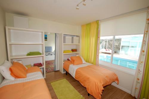 a bedroom with two beds and a window at Seashell - House with private pool and garden in São Martinho do Porto