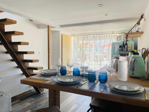 une table en bois avec des verres bleus et des assiettes dessus dans l'établissement L’enraguer, à Marseille
