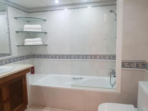 biała łazienka z wanną i umywalką w obiekcie Ático - Edificio Marina Banús- Calle Muelle de Ribera w Marbelli