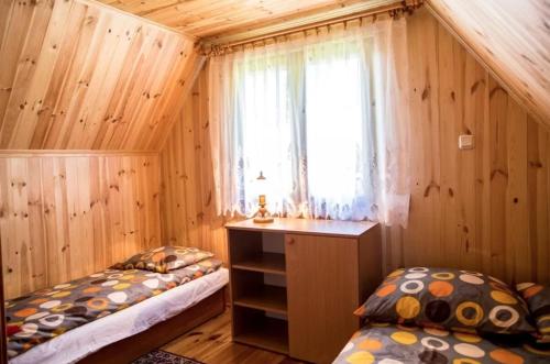 a bedroom with two twin beds and a window at Domek Letniskowy in Lubiatowo