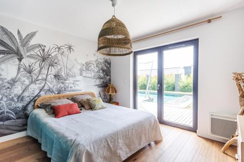 sypialnia z łóżkiem z tropikalnym malowidłem ściennym w obiekcie Paradis - Piscine Privée w mieście Dinan