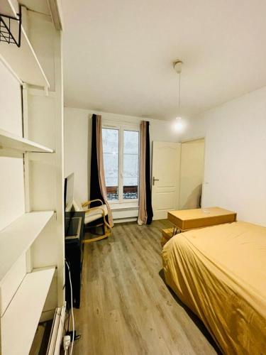 sypialnia z łóżkiem, biurkiem i oknem w obiekcie Appartement en plein coeur du 10eme et proche de plusieurs Gares w Paryżu