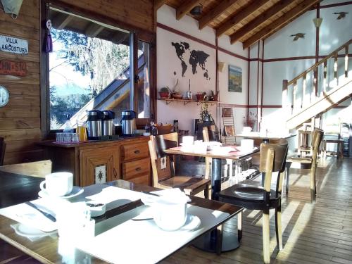a restaurant with tables and chairs and a window at La Roca de la Patagonia in Villa La Angostura