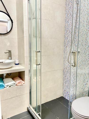 a bathroom with a shower and a toilet and a sink at Pirata Milfontes Guest House in Vila Nova de Milfontes