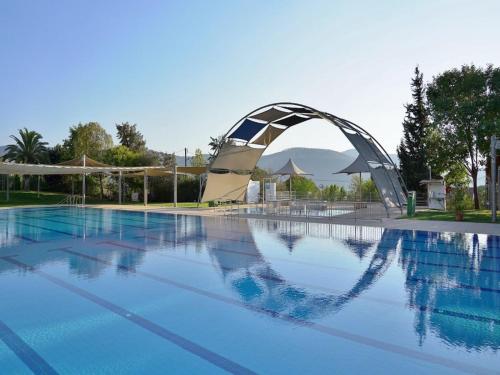 uma piscina com uma ponte de metal sobre ela em Ein Harod Country Lodge em ‘En H̱arod