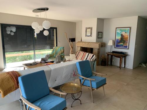Villa de charme à Ajaccio في أجاكسيو: غرفة معيشة مع كراسي زرقاء وأريكة