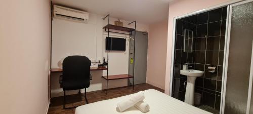 Misto Hotel في كوتا كينابالو: غرفة بسرير وكرسي وحمام