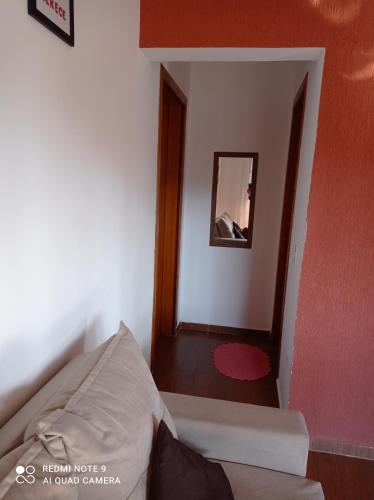 a small room with a bed and a mirror at Cantinho Feliz a 900m do Capivari in Campos do Jordão