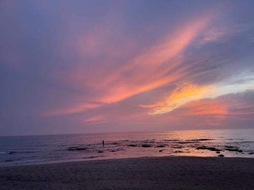 a person standing on the beach at sunset at Domus Lavinia ''Scirocco'' - Anzio in Anzio