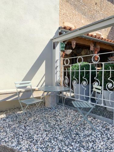 two chairs sitting on a porch with a fence at La Source in Saint-Martin-lʼArs