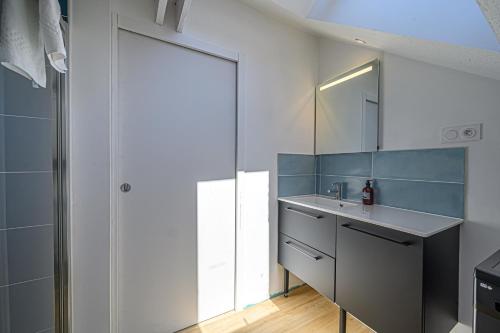 La salle de bains est pourvue d'un lavabo et d'un miroir. dans l'établissement LE BEG ER LANN - Appartement contemporain centre ville Sarzeau, à Sarzeau