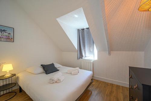 a bedroom with a bed with two slippers on it at LE BEG ER LANN - Appartement contemporain centre ville Sarzeau in Sarzeau
