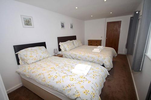 1 dormitorio con 2 camas con sábanas amarillas en No 28C St Benedict en Glastonbury