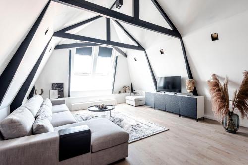 a living room with a couch and a tv at Sack-Time fashion boutique hotel 6 & 7 in Zandvoort