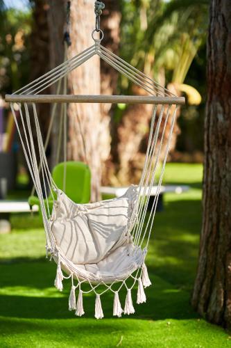 a hammock hanging from a tree in a park at El Oasis Villa Resort in La Eliana