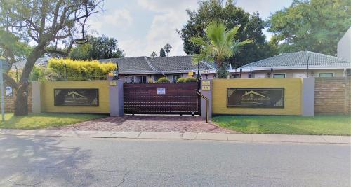 a fence in front of a house with a gate at Unitas Guesthouse in Centurion