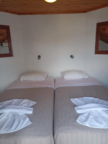 two beds in a room with white sheets and pillows at Oasis - Harbor House in Lithakia