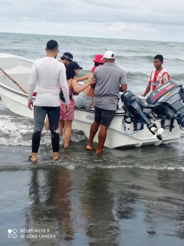 a group of people getting on a boat in the water at HOSTAL BELLEZA TROPICAL in Moñitos